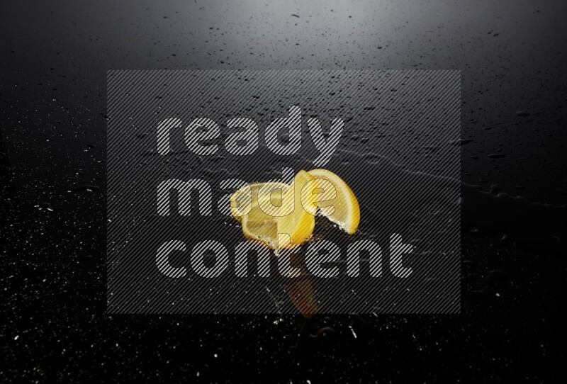Lemon slices with water drops, and droplets on black background