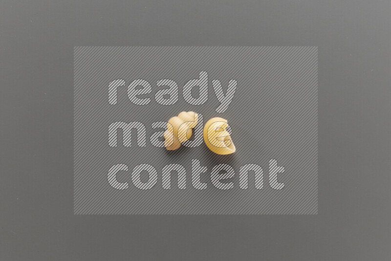 Snails pasta with other types of pasta on grey background