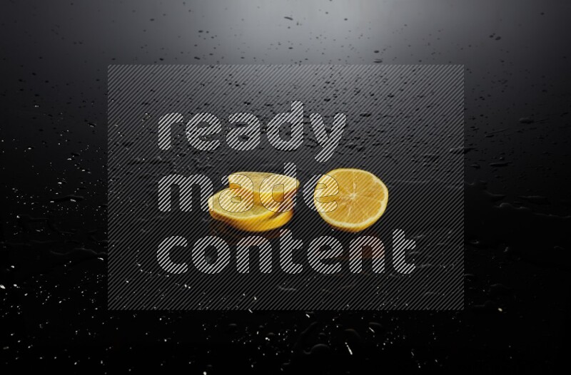 Lemon slices with water drops, and droplets on black background