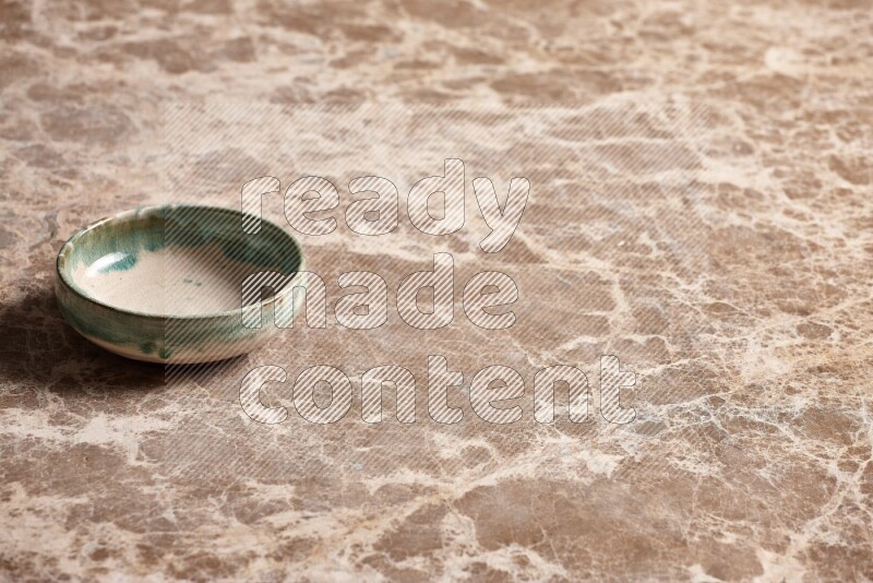 A multicolored pottery plate on beige marble background