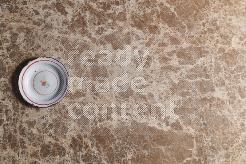 A vintage metal plate on beige marble background