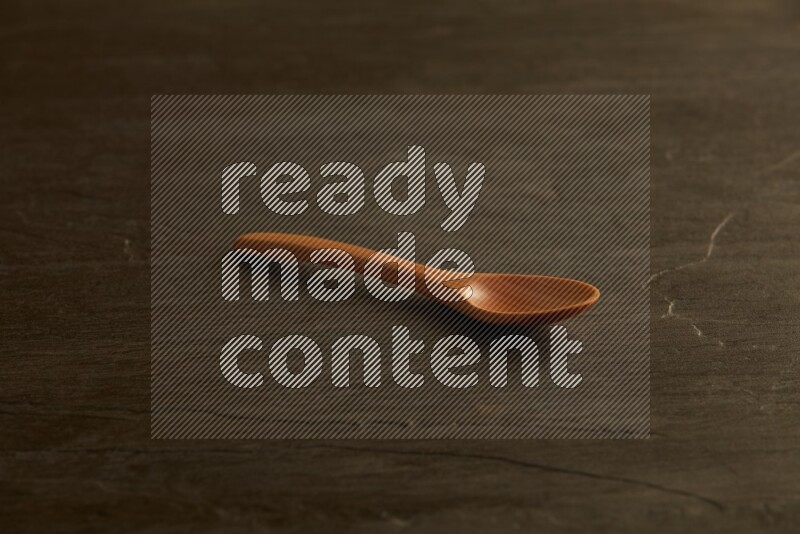 wooden spoon on black slate background