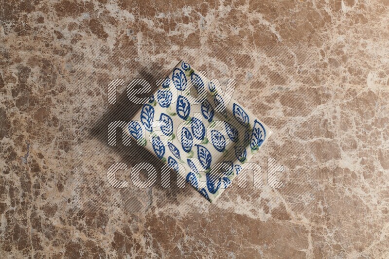 A decorative pottery plate on beige marble background