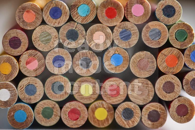A close-up of the tips of colored pencils arranged in a bundle on white background
