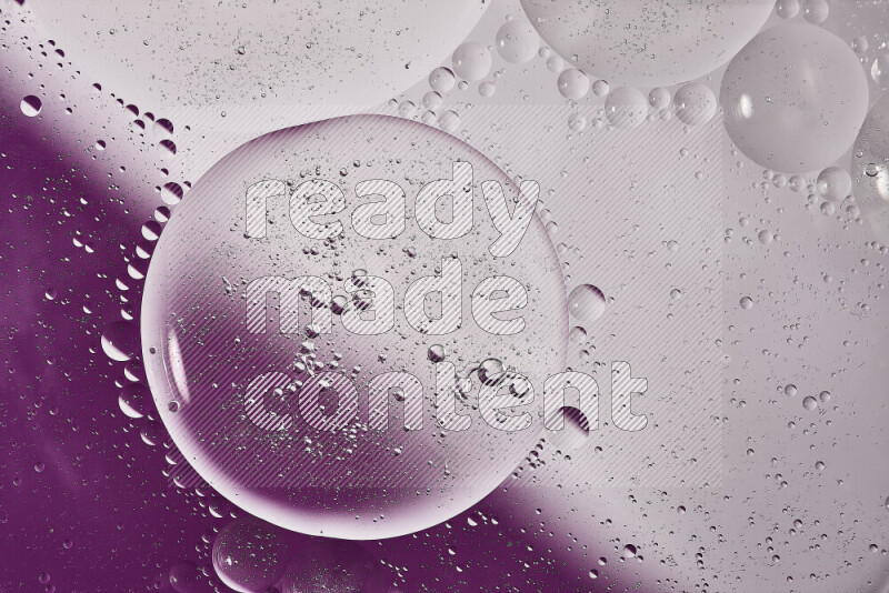 Close-ups of abstract oil bubbles on water surface in shades of white and purple