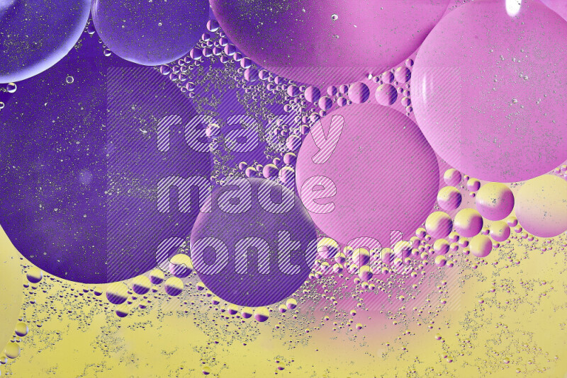 Close-ups of abstract oil bubbles on water surface in shades of yellow, purple and pink