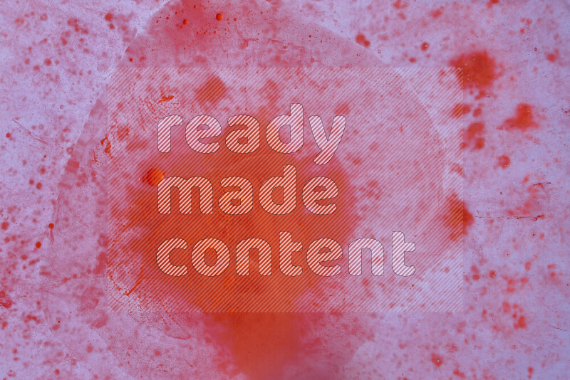 The image captures a dramatic splatter of red paint over a white backdrop