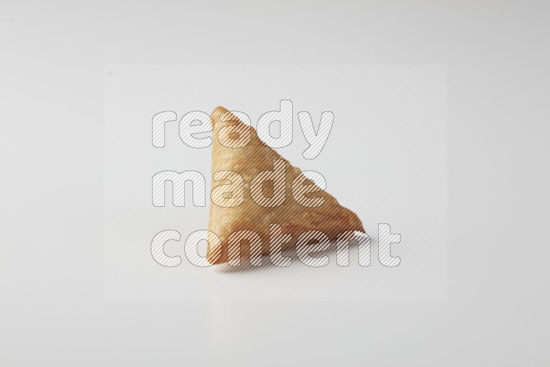 One fried sambosa on a white background
