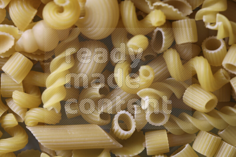 Different pasta types on light blue background