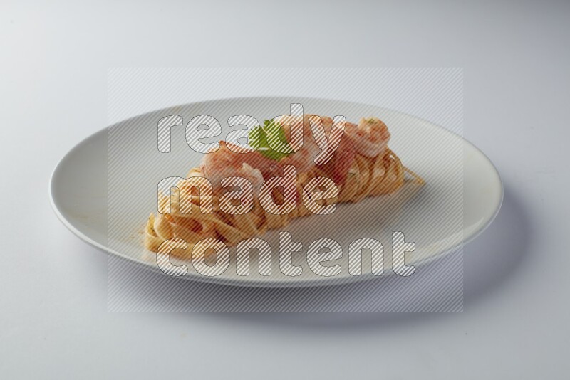 Fettuccini red sauce pasta with shrimp in a white plate on a white background