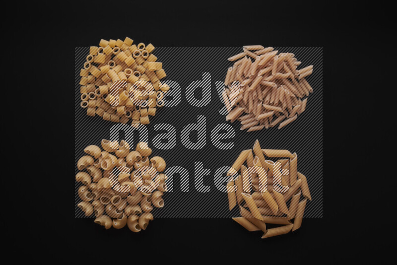 Different pasta types in bunches on black background