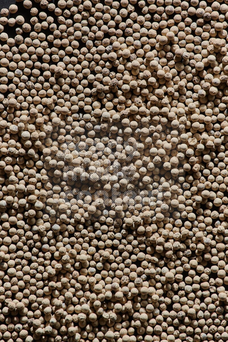 White pepper beads on black flooring