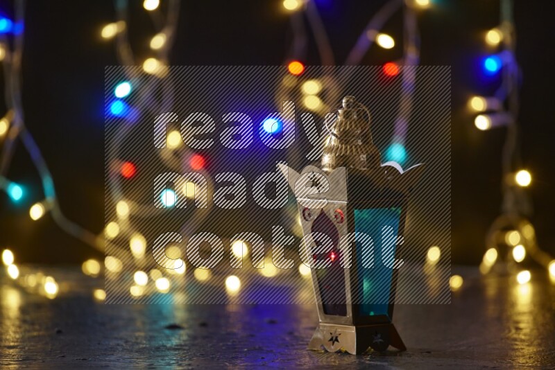 A traditional ramadan lantern surrounded by glowing fairy lights in a dark setup