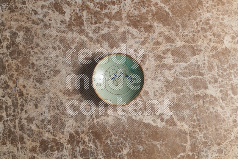A decorative pottery plate on beige marble background