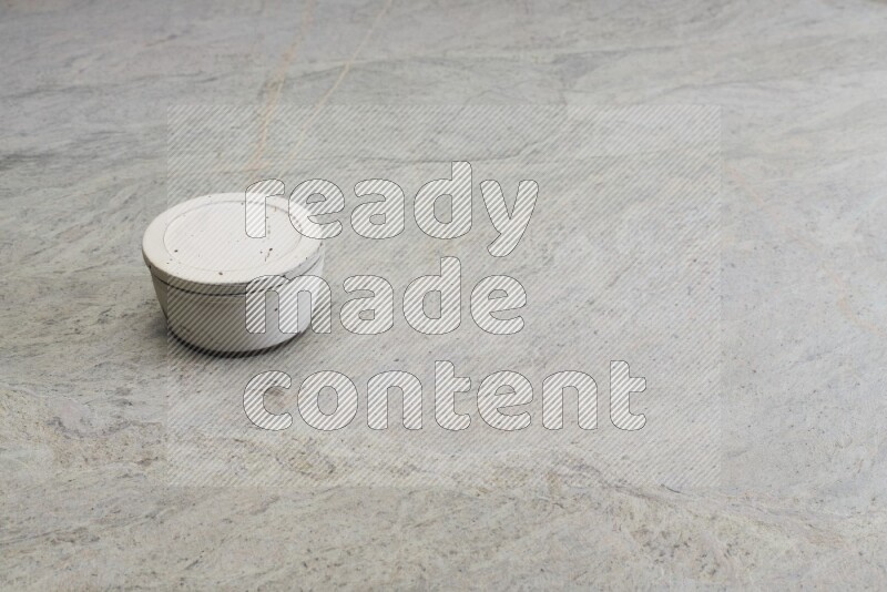 A white pottery bowl on grey marble background