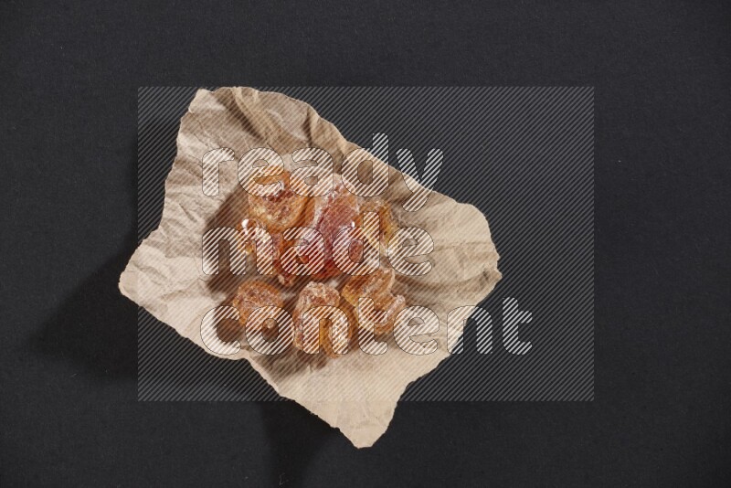 قطعة من الورق المجعد ممتلئة بالصمغ العربي علي خلفية سوداء