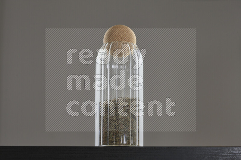 ريحان مجفف في وعاء زجاجي على خلفية سوداء