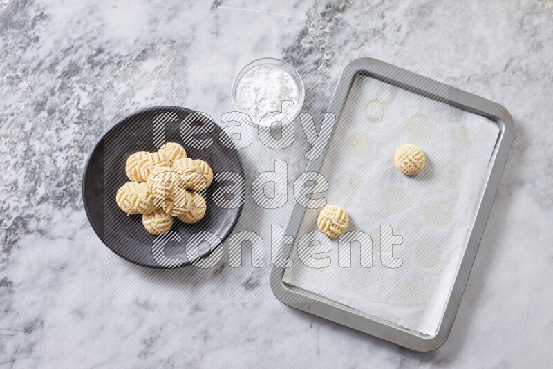 Kahk step by step with its ingredients ghee, sugar, flour, sesame, yeast, water and kahk flavor on grey marble background