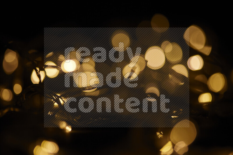 Light bulbs glowing against backdrop of golden bokeh