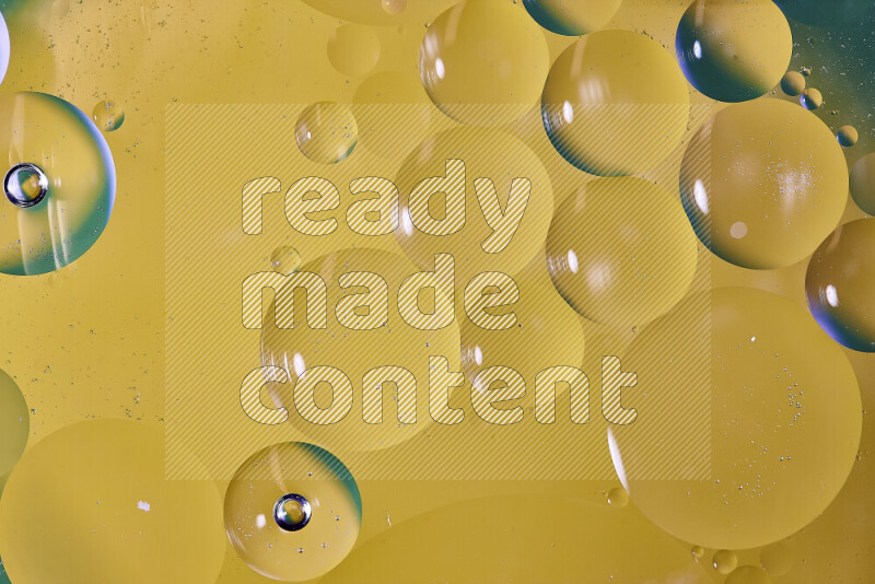Close-ups of abstract oil bubbles on water surface in shades of green and yellow