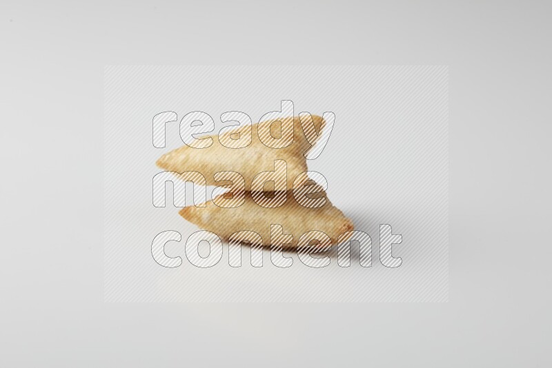 Two fried sambosas on a white background