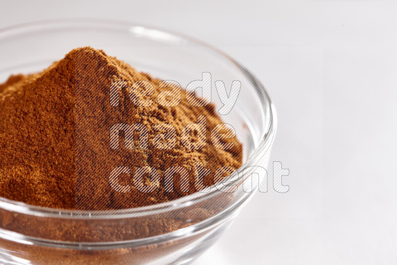 A glass bowl full of ground paprika powder on white background