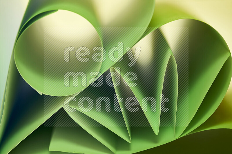 عرض فني لطيات الورق تخلق مزيج من الأشكال الهندسية، مضاءة بإضاءة ناعمة بدرجات اللون الأخضر