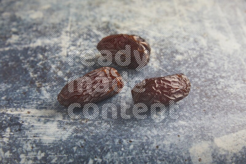 three madjoul dates on a rustic blue backround
