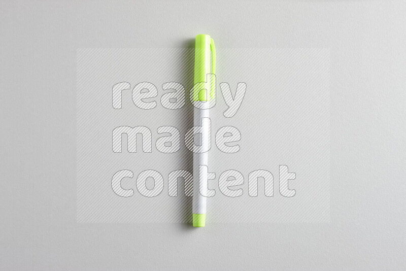 A close-up showing a single coloring pen with a cap on grey background