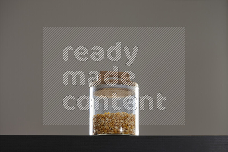 Pop corn in a glass jar on black background