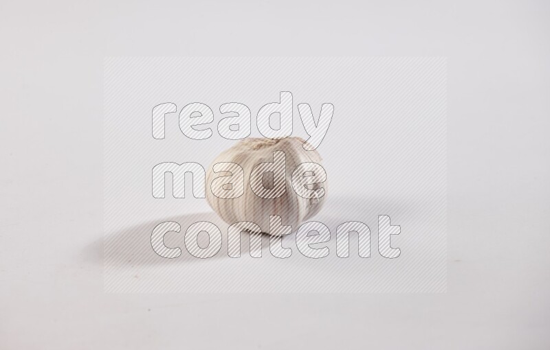 A whole garlic bulb placed on a white flooring