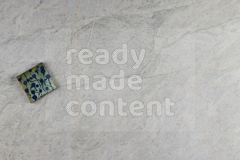 A decorative pottery coaster on grey marble background