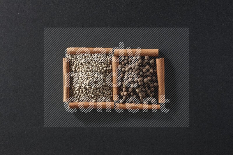 2 squares of cinnamon sticks full of white peppers and allspice on black flooring