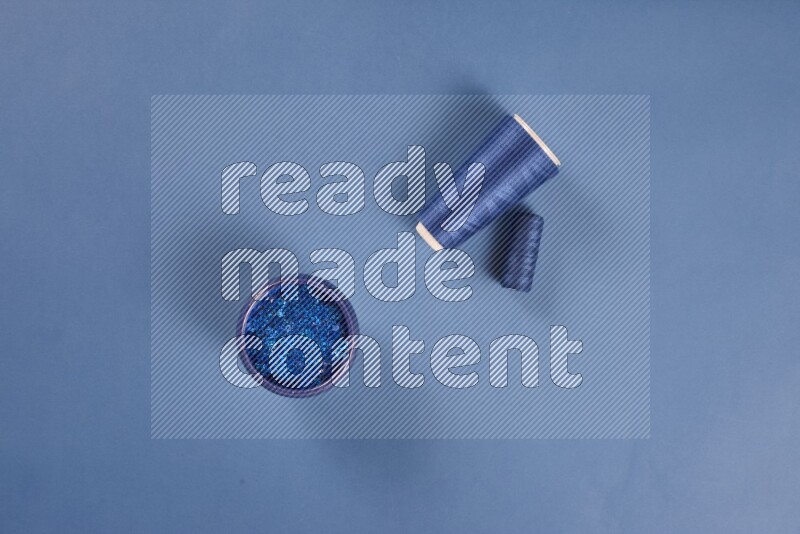 A blue collection of sewing and tailoring tools arranged on a blue background