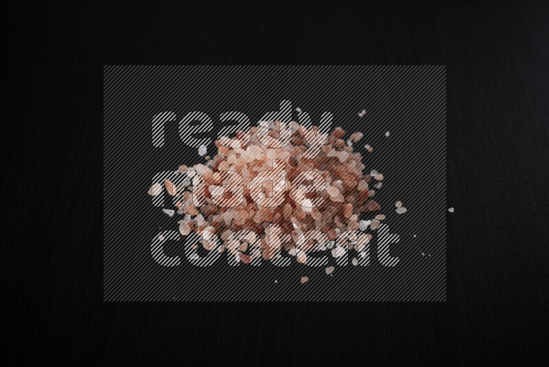 A bunch of coarse himalayan salt crystals on black background
