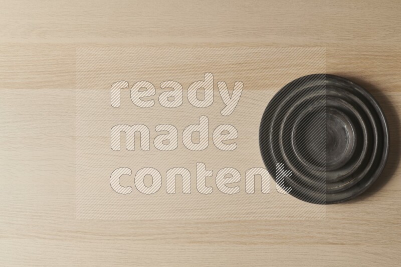 A pottery black ripple plate on light wooden background
