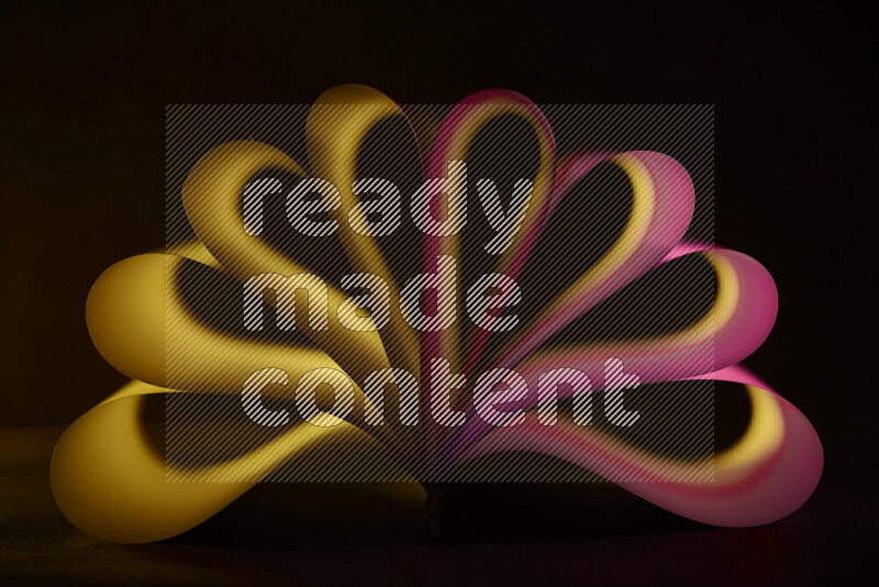 An abstract art piece displaying smooth curves in yellow and pink gradients created by colored light