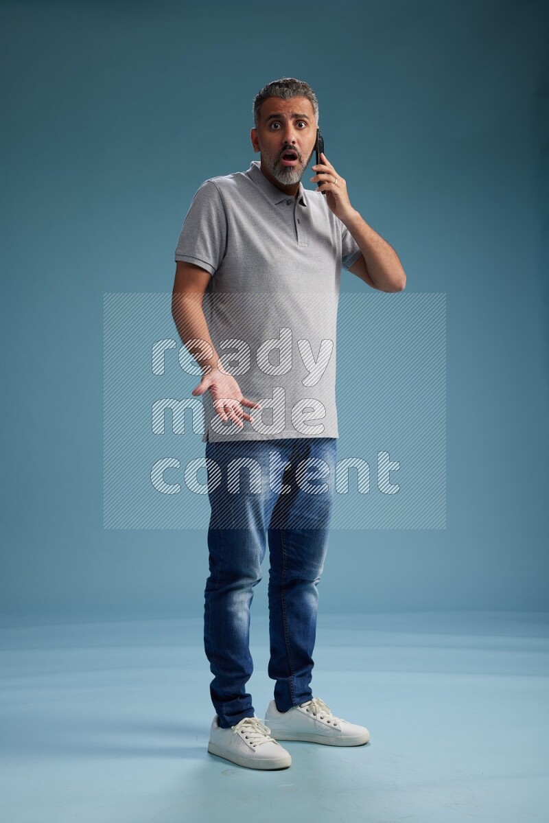 Man Standing talking on phone on blue background