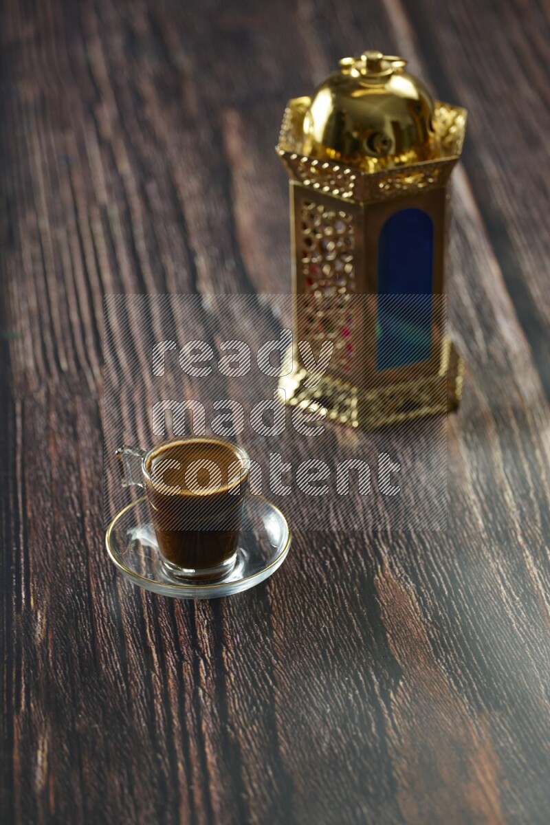 A golden lantern with different drinks, dates, nuts, prayer beads and quran on brown wooden background