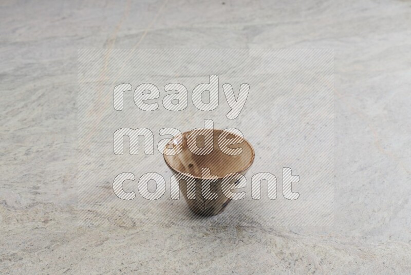 A multicolored pottery Cup on grey marble background