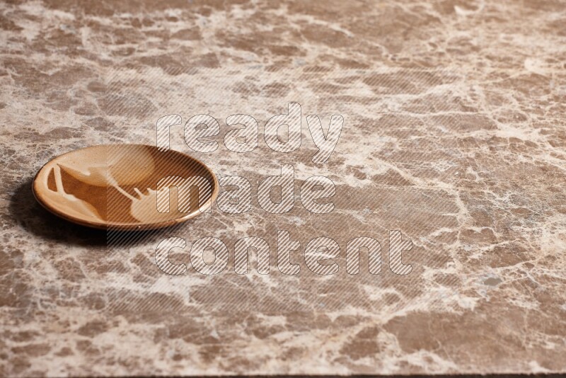 A multicolored pottery plate on beige marble background