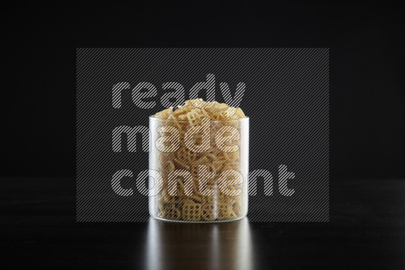 Snacks in a glass jar on black background