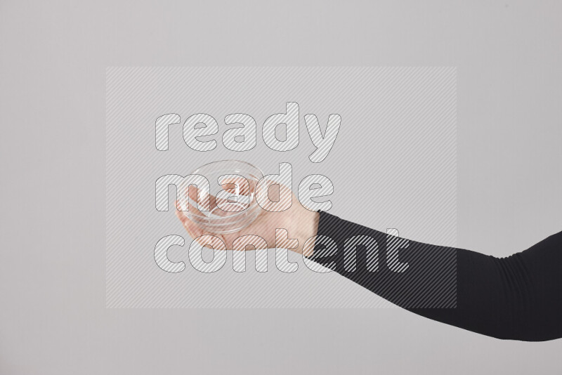 امرأة ترتدي عباءة سوداء تحمل أدوات زجاجية مختلفة في أوضاع متعددة