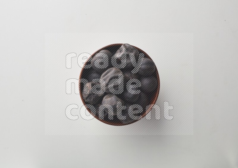 Top-view shot of dried lime (loomi) in a container on white background