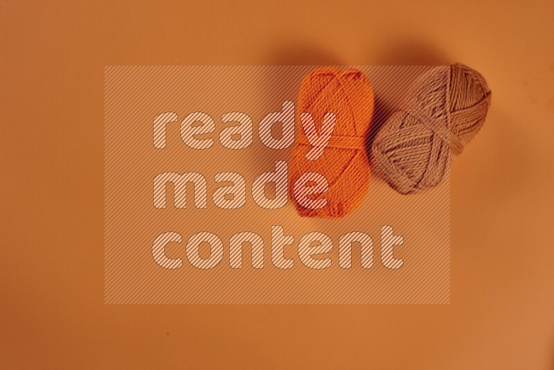 An orange collection of sewing and tailoring tools arranged on a orange background