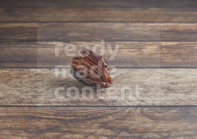 pecan stuffed madjoul date on a wooden background