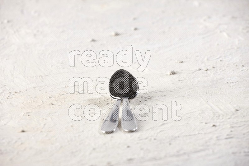 2 metal spoons full of black seeds on textured white flooring