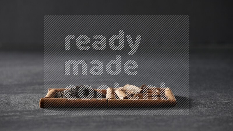 2 squares of cinnamon sticks full of tea and cinnamon on black flooring