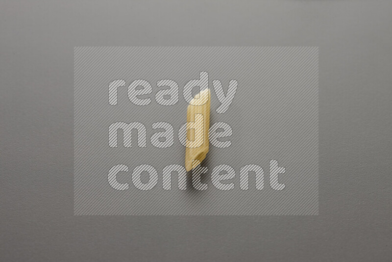 Mini penne pasta on grey background