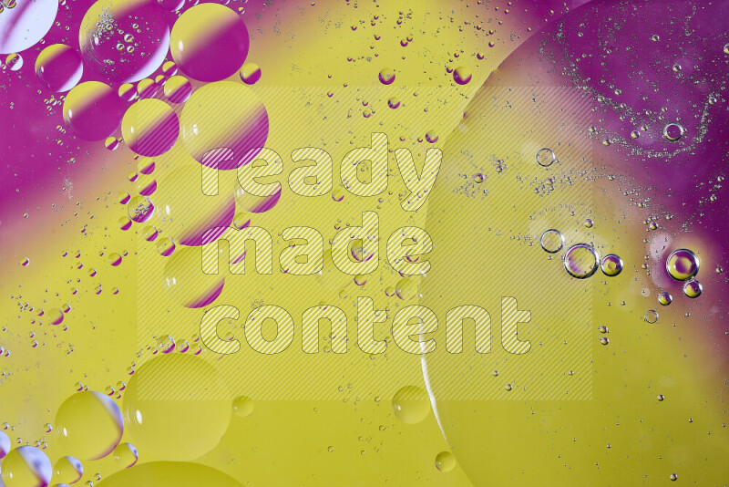 Close-ups of abstract oil bubbles on water surface in shades of yellow and pink